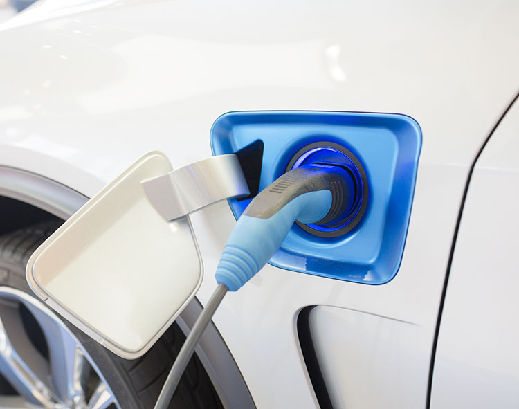 Een elektrische auto wordt opgeladen via een blauwe laadkabel aangesloten op de laadpoort.